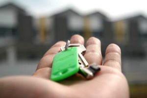 A man holding the keys to his first apartment