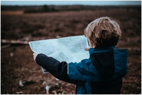 a young boy looking at a map while travelling