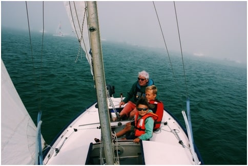 happy children enjoying a sailing experience with their family