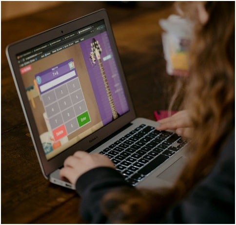 a girl practising her maths sums on a laptop while travelling